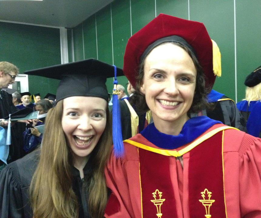 Jessica and Nicole at PhD graduation in 2012. Both women are smiling and wearing graduation regalia.